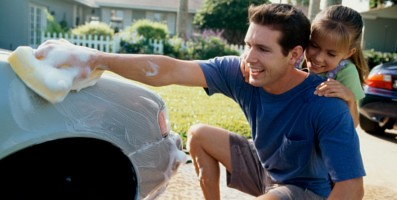 Father with daughter washing the family insured car.