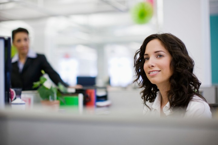 Smiling woman in a corporate office.